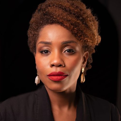 Luxury Makeup and Hair, a woman with curly hair wearing earrings and a black jacket